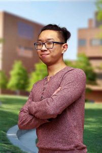 A three quarter portrait of Eric on the Library green.