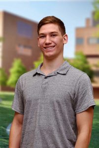 A three quarter portrait of Mark on the Library green.