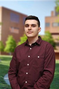 A three quarter portrait of Manos on the Library green.